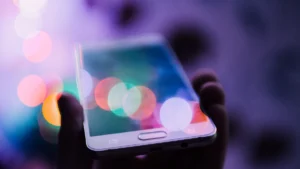 Hand som håller en smartphone med färgglada ljus