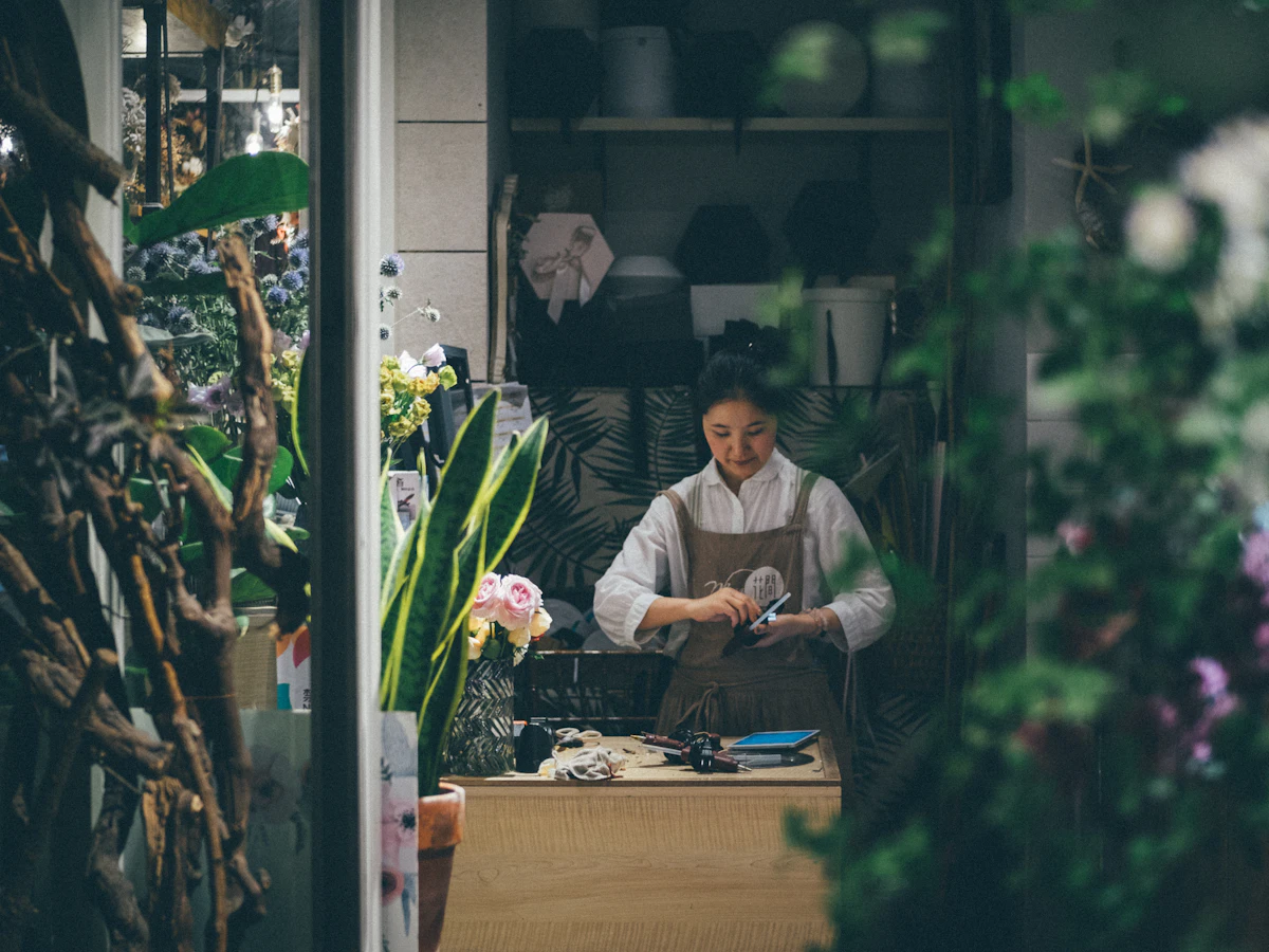 Ägare av en blomsterhandel arbetar i sin butik